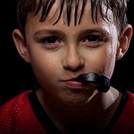 Boy with black mouthguard in mouth