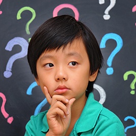 Little boy with question marks around his head