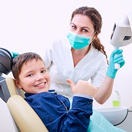 Young boy giving a thumbs up at the dentist’s office