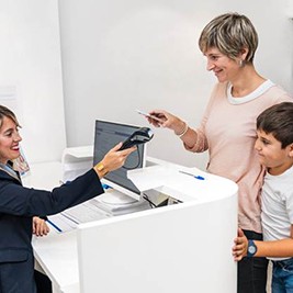 Mother paying for her child’s dental treatment