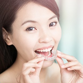 Woman placing Invisalign tray