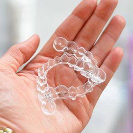 Hand holding set of aligners