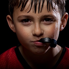 Boy with black mouthguard in mouth