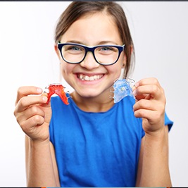 Young girl holding retainers