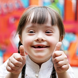 Young girl smiling and giving thumbs up