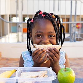 Child smiling while eating lunch at school