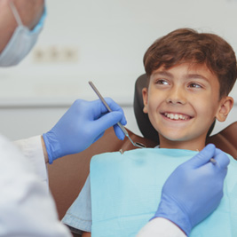 Happy young boy smiling at his dentist