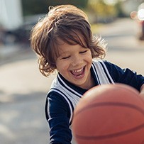 Smiling child playing basketball