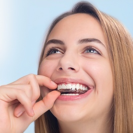 Teen placing Invisalign tray