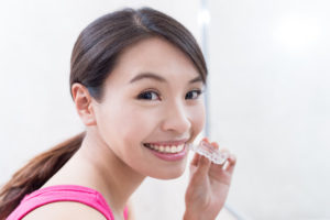 Young woman holding clear alignment tray