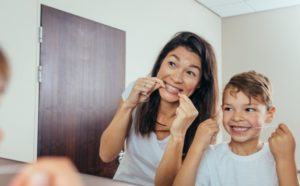 Mom teaching son to floss.