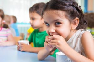 Little girl eating smile-friendly foods for lunch