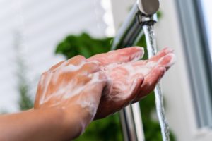 Someone practicing handwashing in COVID-19 as recommended by Auburn family dentist