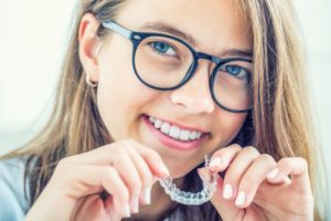 Girl smiling with Invisalign tray