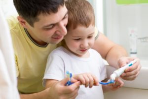 father teaches son to brush teeth recommended by Auburn children's dentist