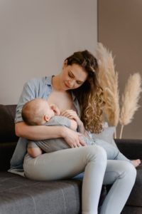 Mother nursing her child on couch