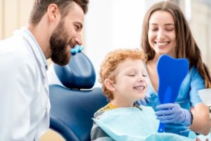 Young boy looking in dental mirror